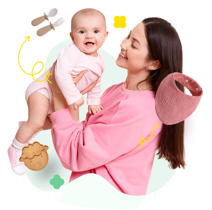 Woman holding a baby with various baby items around them on a white background